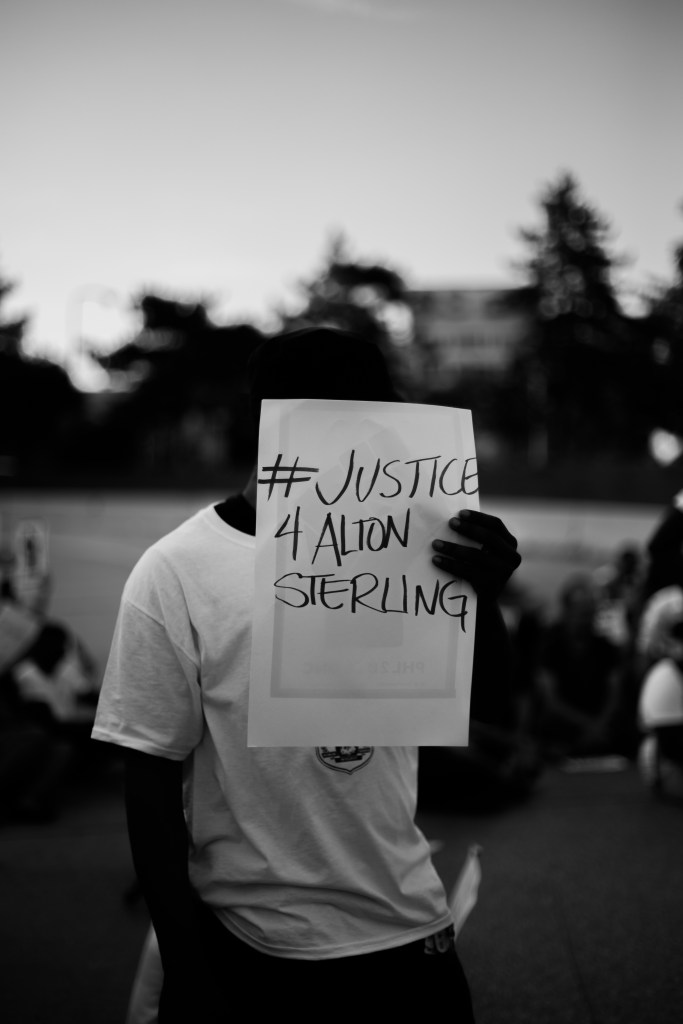 A man holds a sign reading "#Justice4AltonSterling" during a demonstration in Philadelphia.