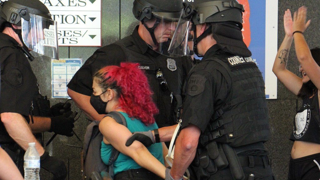 Police lead a protester away during a protest inside Philly's Municipal Services Building on June 23, 2020
