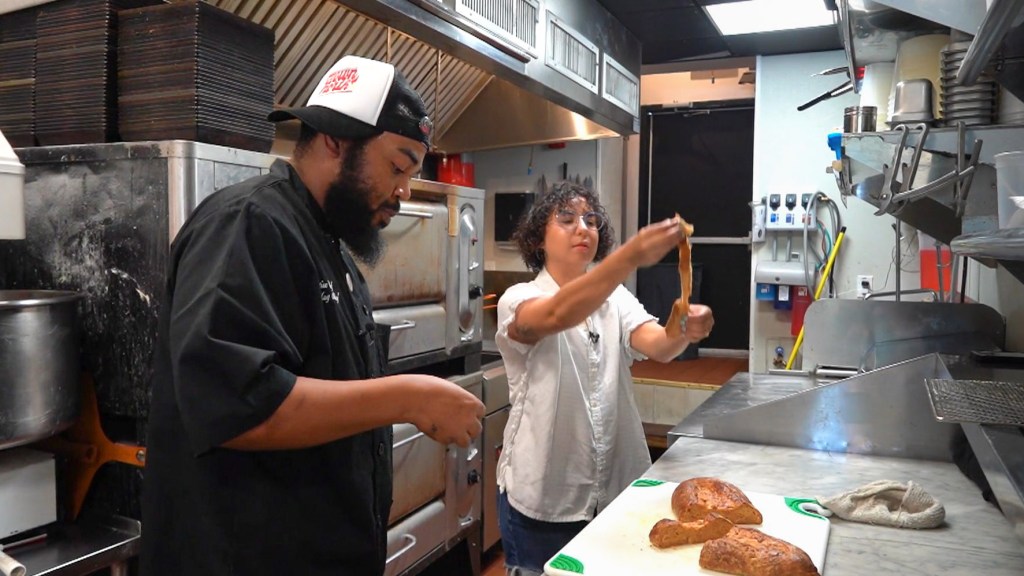 Chef Michael Carter and author Alisha Miranda pull apart the non-pork lard bread at Down North Pizza
