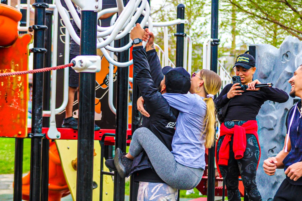 Adults taking advantage of the playground equipment during 'The Block Gives Back' event
